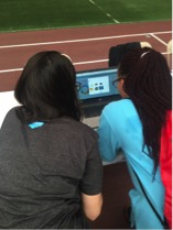 Salesforce employee volunteer get hands on with Wave Analytlcs activity and local middle school girl.