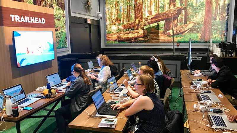Learning is more fun when you do it in the community! Photo of Dreamforce attendees working on Trailhead trails together.
