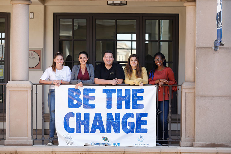 University of San Diego students with a banner saying “Be The Change.”