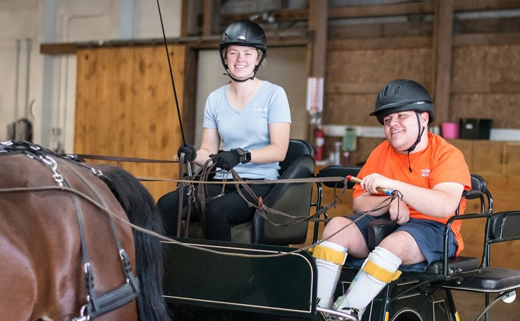 High Hopes participant, Mac, with Advanced Instructor, Sarah Miller, during a therapeutic carriage driving lesson.