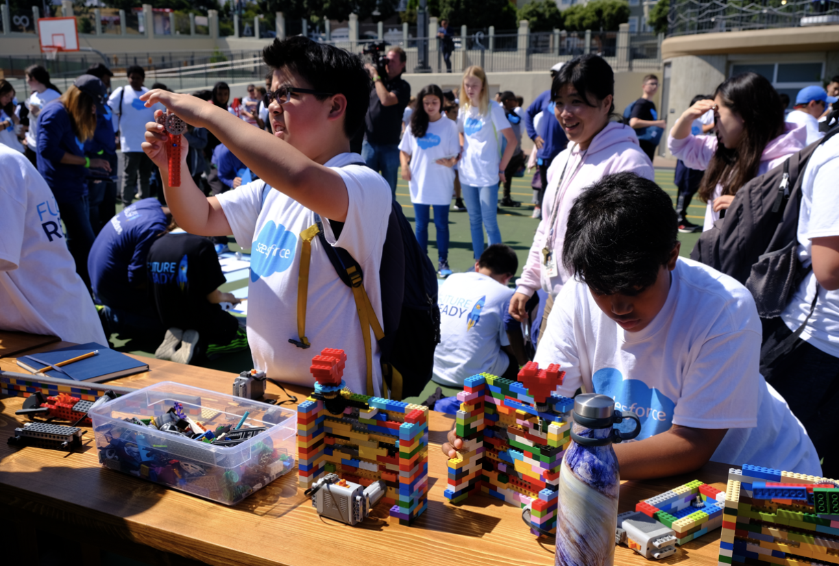 Students at a Salesforce volunteer event using LEGOs powered by electronics to learn engineering skills. Choosing a platform is similar to having the right building blocks to create what you want, as well as options to create things out of the box.