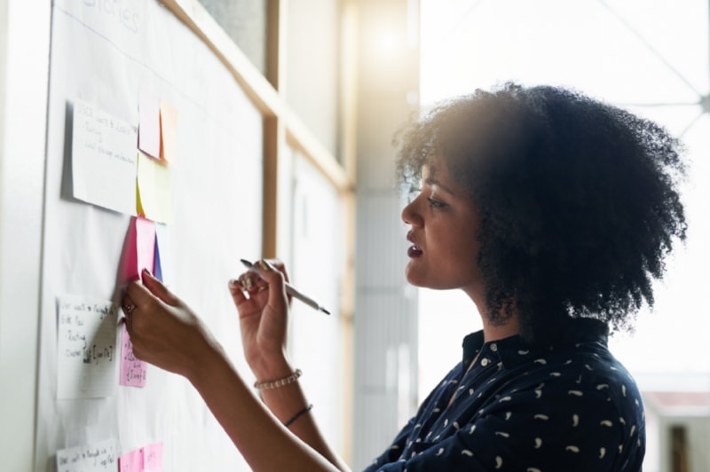 Salesforce volunteer brainstorming on post-its on a wall for a pro bono project