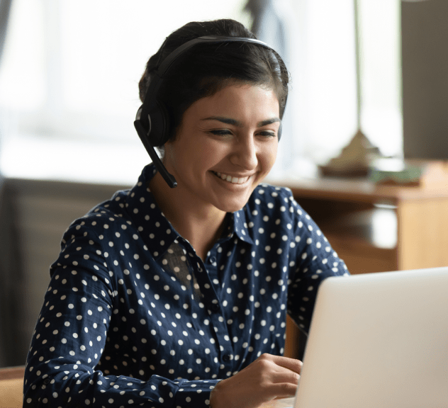 woman with a headset looking at a computer