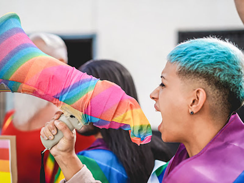 Person using a megaphone to amplify voice at a Pride event